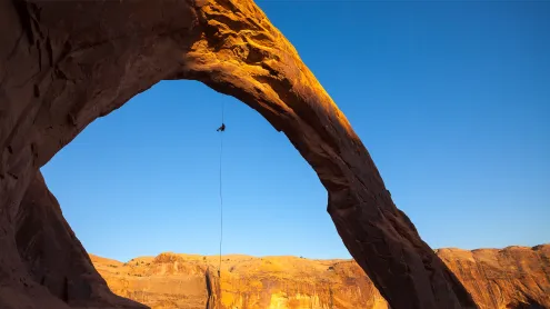 A man rappels off Corona Arch near Moab, Utah (© Grant Ordelheide/TANDEM Stills + Motion)