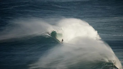 Surfer riding a wave in Nazaré, Portugal (© Rui Caria/Getty Images)