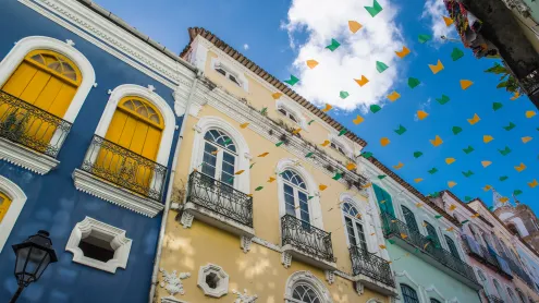 Rua em Salvador decorada com bandeiras coloridas entre prédios (© Henn Photography/Aurora Photos/Getty Images)
