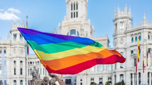 Brazos agitando la bandera LGBTQIA en la Plaza de Cibeles en Madrid, España (© Jose Gonzalez Buenaposada/Getty Images)
