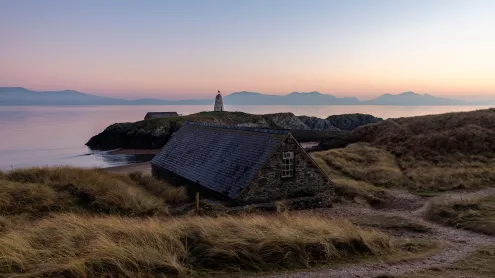 Cottage with Tŵr Mawr Lighthouse in the background, Ynys Llanddwyn, Wales (© Westend61 on Offset/Shutterstock)