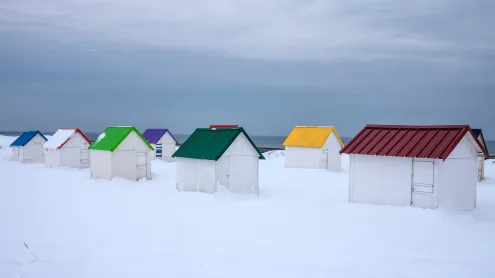 Cabanes aux toits colorés recouvertes de neige à Gouville-sur-Mer, Normandie (© Andia/Getty Images)